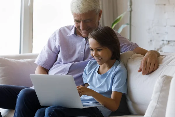 Feliz niño pequeño y viejo abuelo usando la computadora. —  Fotos de Stock