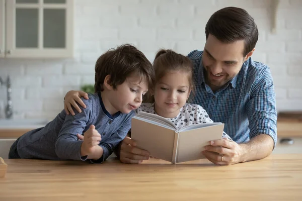 사랑하는 아버지와 두 자녀 가집에서 책을 읽고 있는 모습 — 스톡 사진