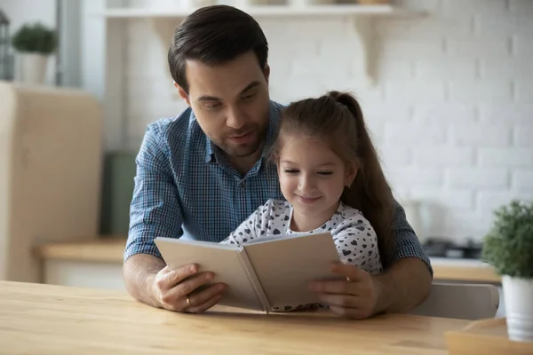 Caring Caucasian father with 9s daughter reading book together — Stock Photo, Image