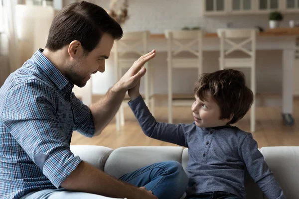 Overjoyed father and little son giving high five, celebrating success — Stockfoto