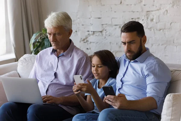 Feliz família de três gerações usando dispositivos em casa. — Fotografia de Stock