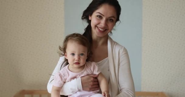 Glückliche junge hispanische Mutter hält süßes kleines Mädchen in den Armen — Stockvideo