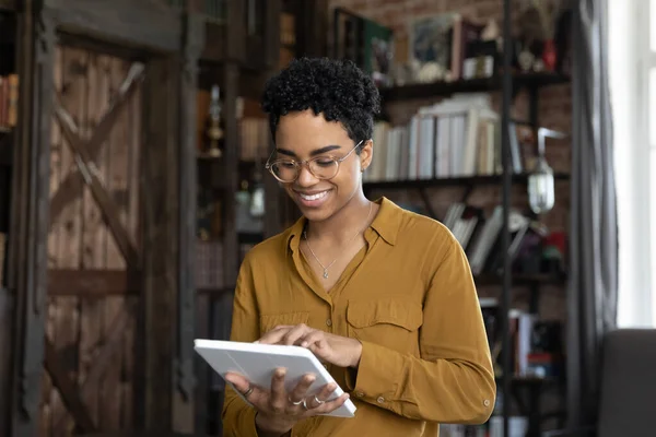 Smiling millennial African American woman using tablet. — Stock Photo, Image
