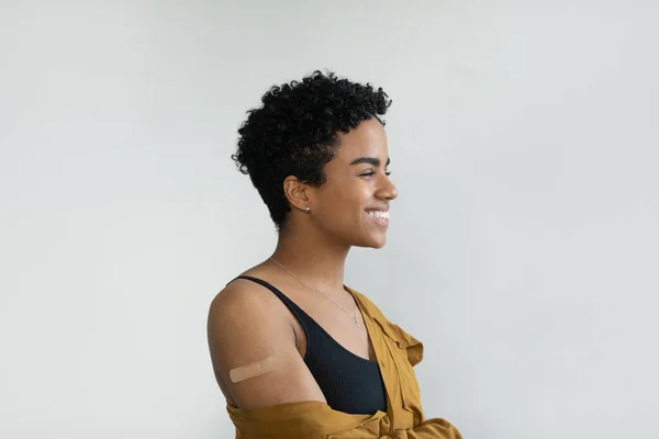 Soñadora joven afroamericana mostrando parche en el brazo. — Foto de Stock