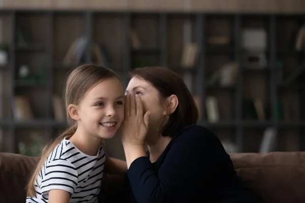 Anciana abuela susurrar divertido secreto en preadolescente nieta oído — Foto de Stock