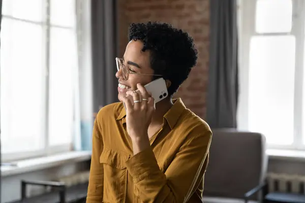Feliz risa millennial afroamericana mujer celebración de conversación de llamada telefónica. —  Fotos de Stock