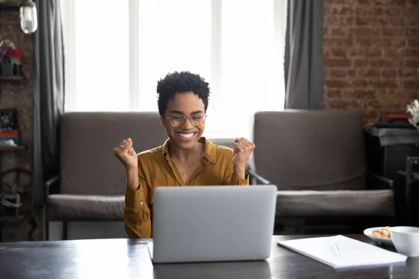 Glücklich lachende junge Afroamerikanerin feiert Interneterfolg. — Stockfoto