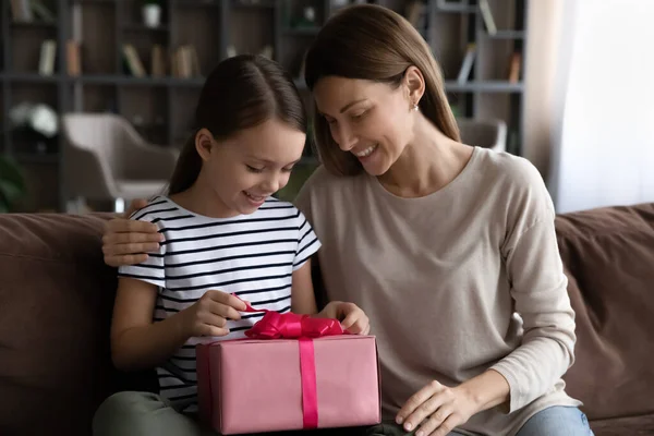 Feliz chica sentarse en sofá con mami desempaquetar presente caja — Foto de Stock