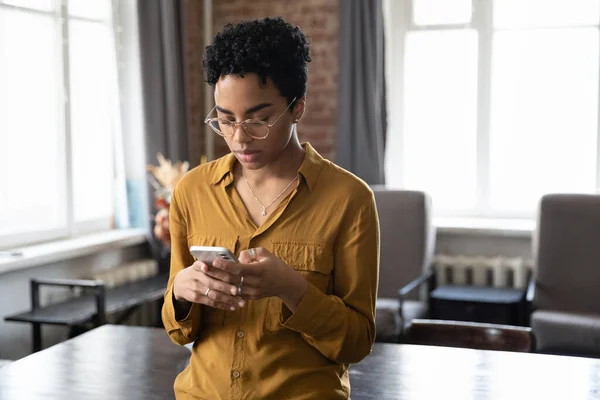 Несчастная молодая афроамериканка пользуется мобильным телефоном. — стоковое фото