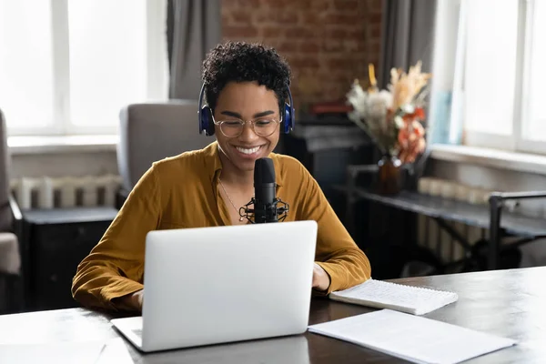 Smiling African American woman recording audio in professional stand microphone. — Stock Photo, Image