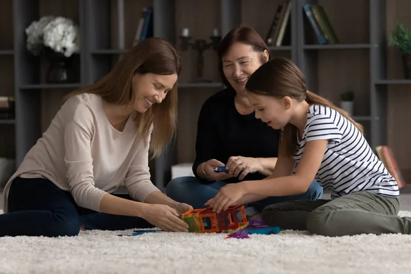 Amistosa familia de 3 hembras de diversas edades jugando constructor juntos —  Fotos de Stock