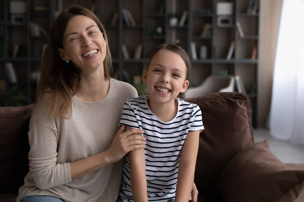 Portret van vrolijke kleine meisje lachen grappen met jonge nanny — Stockfoto