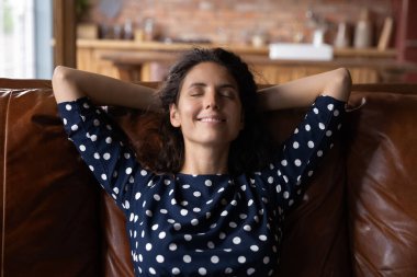 Huzurlu, mutlu, İspanyol bir kadın rahat koltukta dinleniyor..