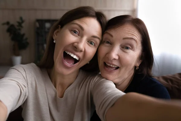 Joyful figlia cresciuta prendendo divertente selfie insieme con la madre in pensione — Foto Stock
