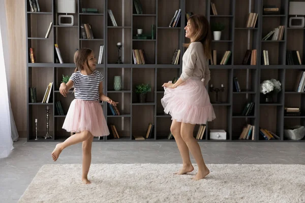 Overblij oudere en jongere zussen gekleed in pettiskirts dansen samen — Stockfoto