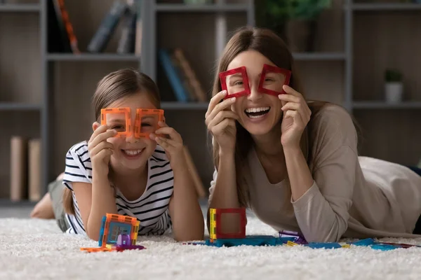 Молодая мать и школьница дочь делают бинокль магнит конструктор — стоковое фото