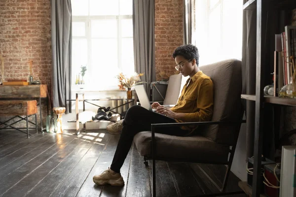 Concentrated young African American woman working on online project. — 图库照片