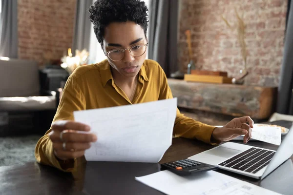 Focused young African American woman managing financial affairs. — 图库照片