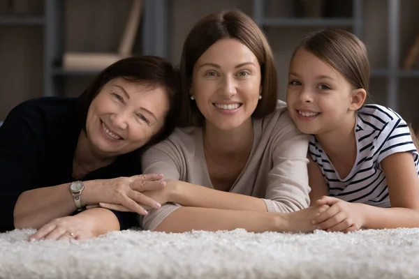 Loving family dynasty of 3 females cuddle look at camera - Stock-foto