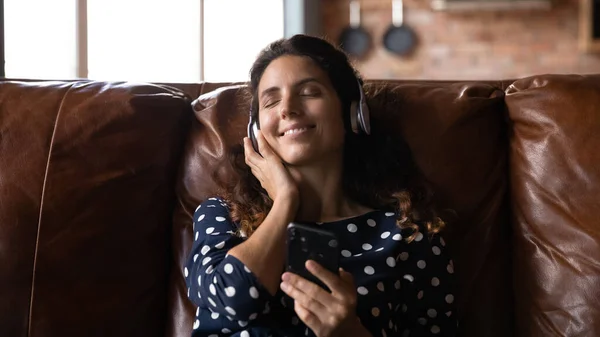 Blij jonge Spaanse vrouw luisteren favoriete muziek. — Stockfoto
