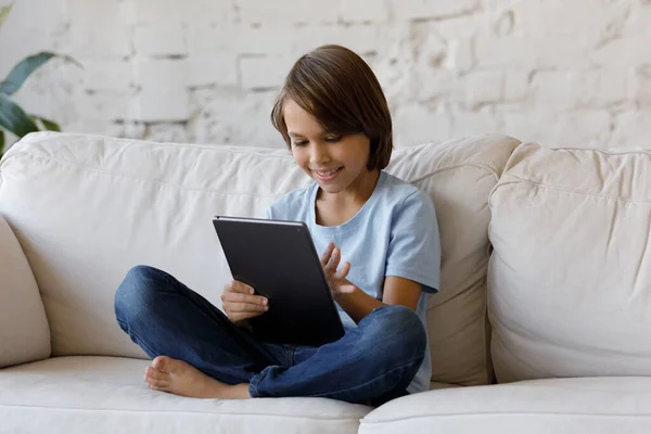 Happy kleine tiener jongen met behulp van digitale tablet thuis. — Stockfoto