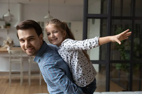 Porträt lächelnder kaukasischer Vater huckepack unterstützt 8s Tochter vorgibt zu fliegen — Stockfoto