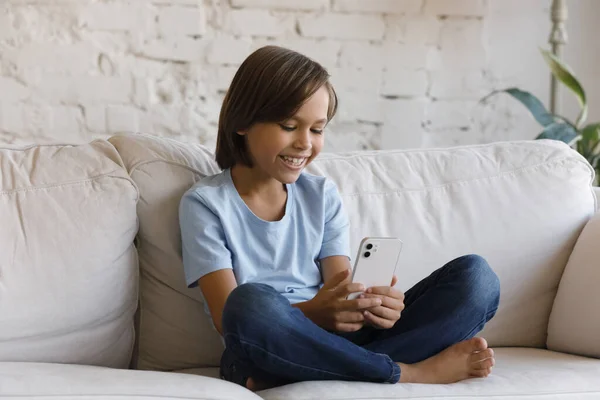 Boldog tinédzser fiú használja a mobilját otthon. — Stock Fotó