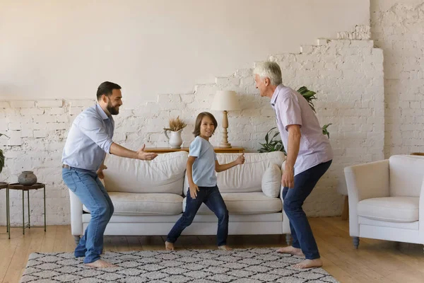 Feliz familia de tres generaciones masculinas bailando en casa. — Foto de Stock