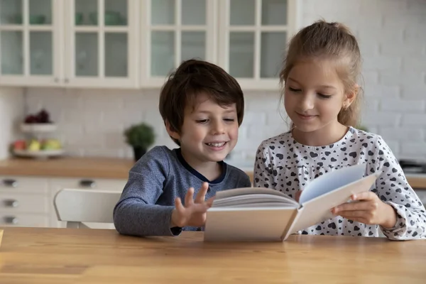 Roztomilý chlapec a dívka čtení pohádkové knihy spolu — Stock fotografie