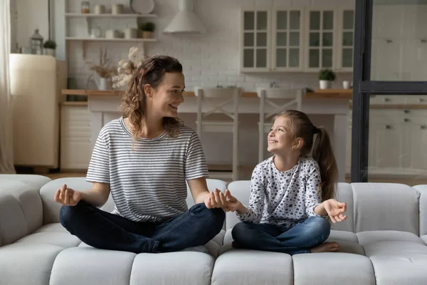 Madre feliz con hija pequeña meditando, practicando yoga juntos — Foto de Stock