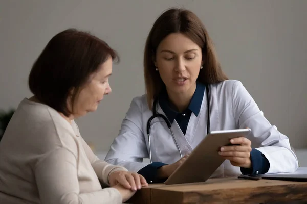 Médica mostra resultado do teste no tablet pc para paciente — Fotografia de Stock