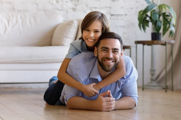 Retrato de un joven sonriente sosteniendo a su hijo adolescente. — Foto de Stock