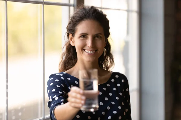 Portrait of smiling latin woman holding glass of cool mineral water, — Stock Photo, Image
