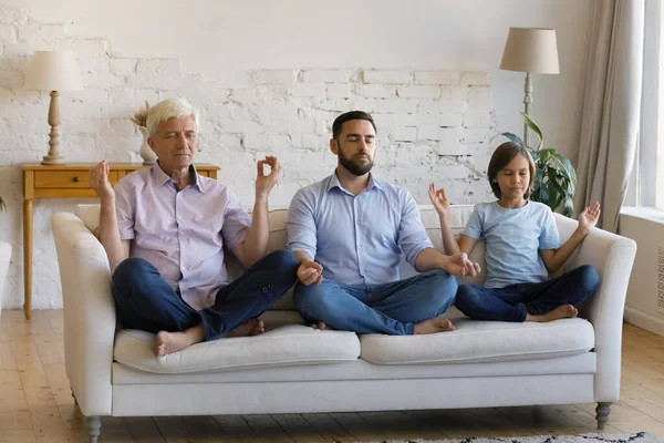 Feliz relajado tres generaciones masculinas familia practicando yoga ejercicios de respiración. — Foto de Stock