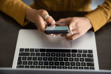 Yukarıda cep telefonu kullanan genç bir kadın var..