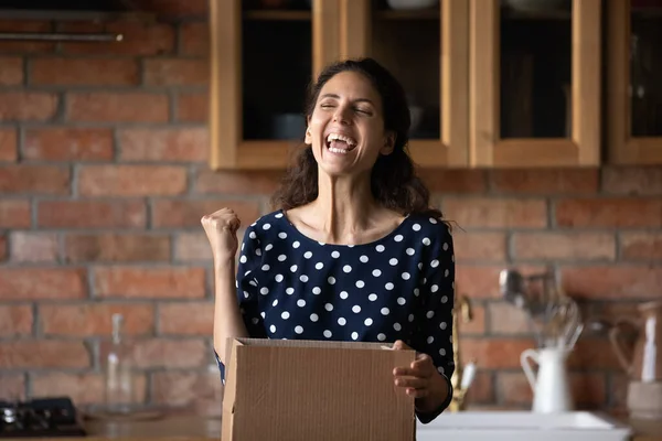 Emotional happy young hispanic woman unpacking huge cardboard box. — Stock Photo, Image