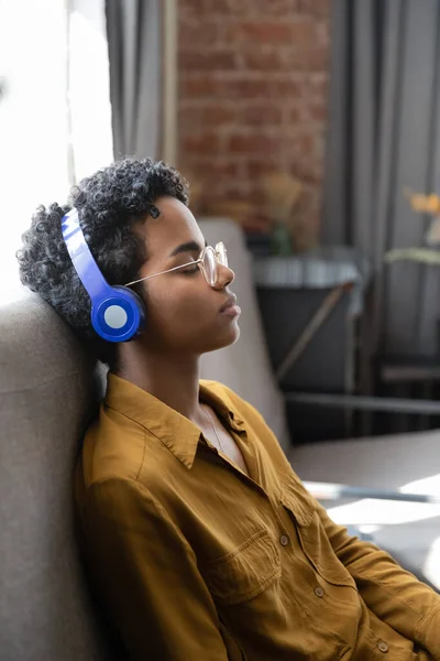 Jovem afro-americana exausta descansando, ouvindo música. — Fotografia de Stock