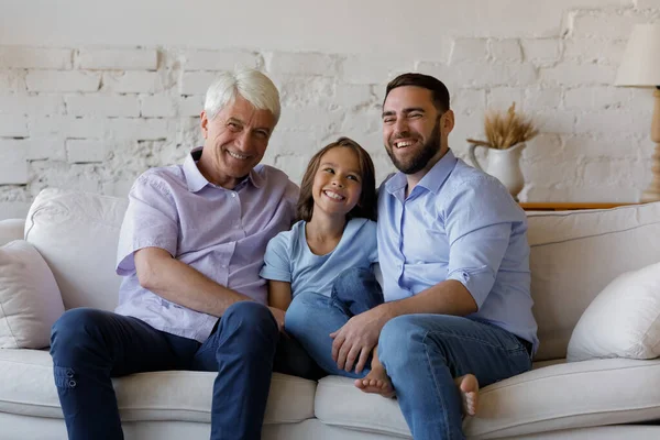 Glückliche Familie dreier männlicher Generationen im Gespräch zu Hause. — Stockfoto