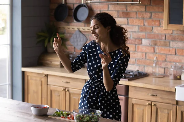 Joyful young hispanic woman dancing preparing food at home. — Stock Photo, Image