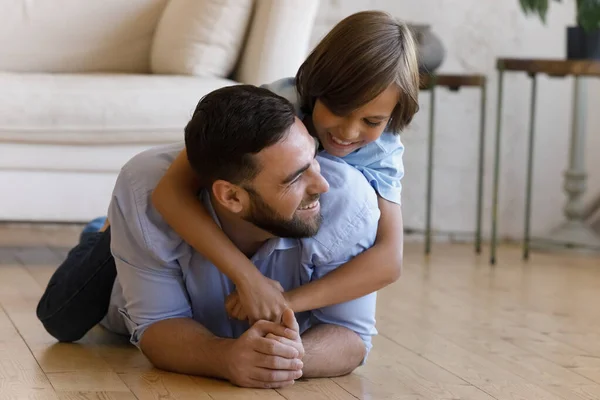 Happy teenage son playing with caring young father. — Stockfoto