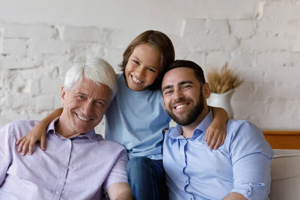 Portrait of smiling teen kid, old grandfather and young father. — Stock Photo, Image