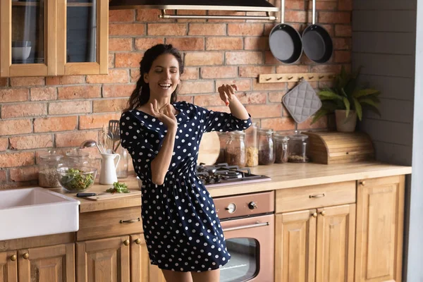 Happy energetic young woman dancing in kitchen. — Stock Photo, Image