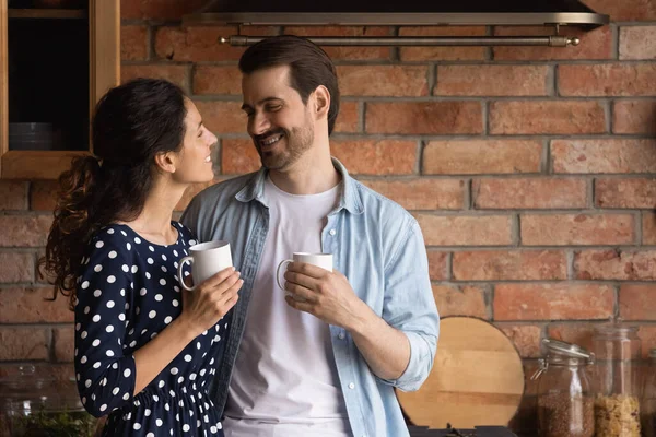 Happy young family couple drinking coffee in kitchen. — 图库照片