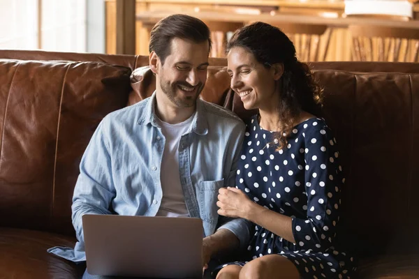 Alegre cariñoso joven familia pareja usando computadora. — Foto de Stock