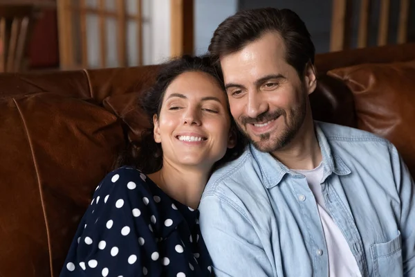 Happy affectionate man and woman resting on cozy sofa. — Stockfoto