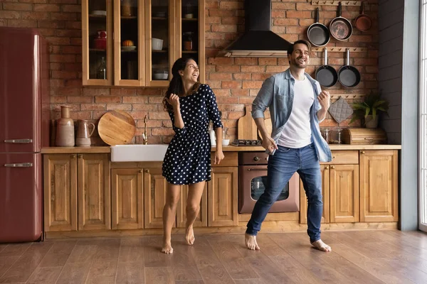 Cheerful young married couple dancing together in kitchen. — 图库照片