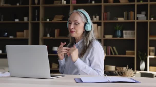 Retired female in headset hold distant class to remote students — Video Stock