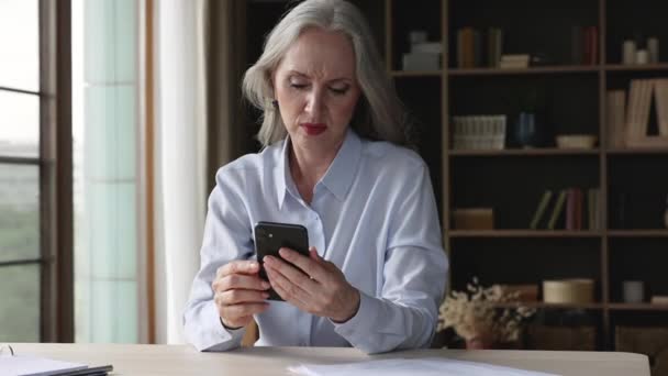 Empresaria anciana nerviosa recibe correo electrónico sobre la deuda en el teléfono — Vídeo de stock