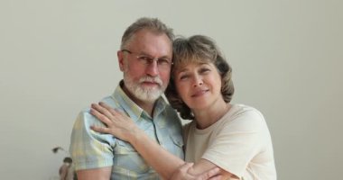 Mutlu aile portresi, sevgi dolu yaşlı çift kameraya bakıyor.