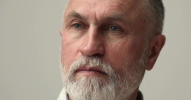 Beyaz sakallı, ciddi, düşünceli, son sınıf öğrencisinin bakışları başka yöne bakıyor.